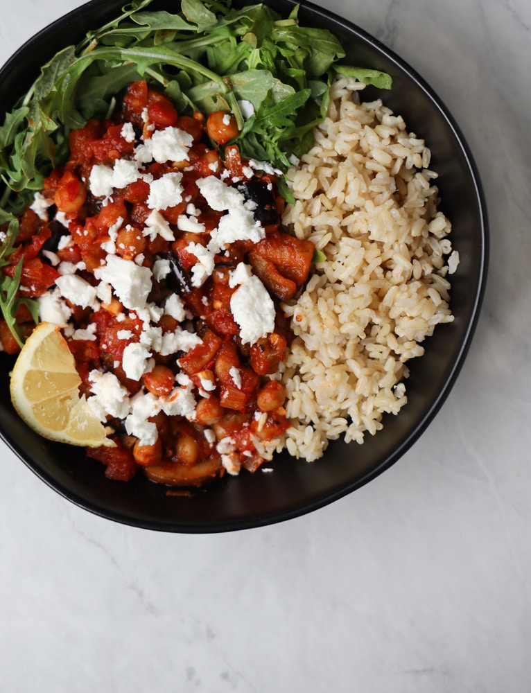 harissa chickpeas in a bowl with brown rice and arugula