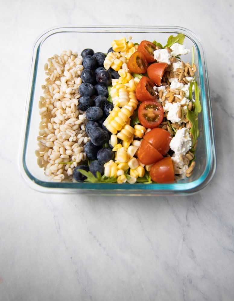 summer grain bowl with cherry tomatoes, corn and blueberries