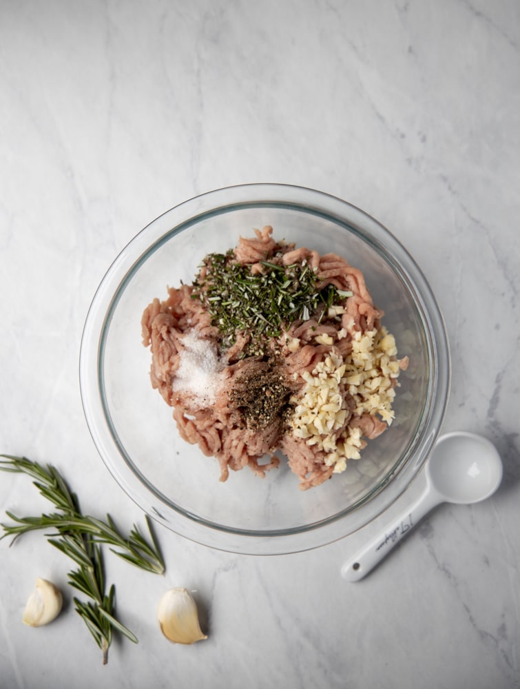 ground turkey in a bowl with garlic and rosemary