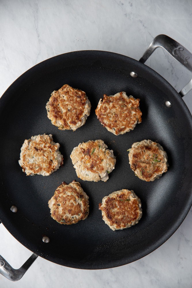 rosemary garlic turkey burger patties in a skillet