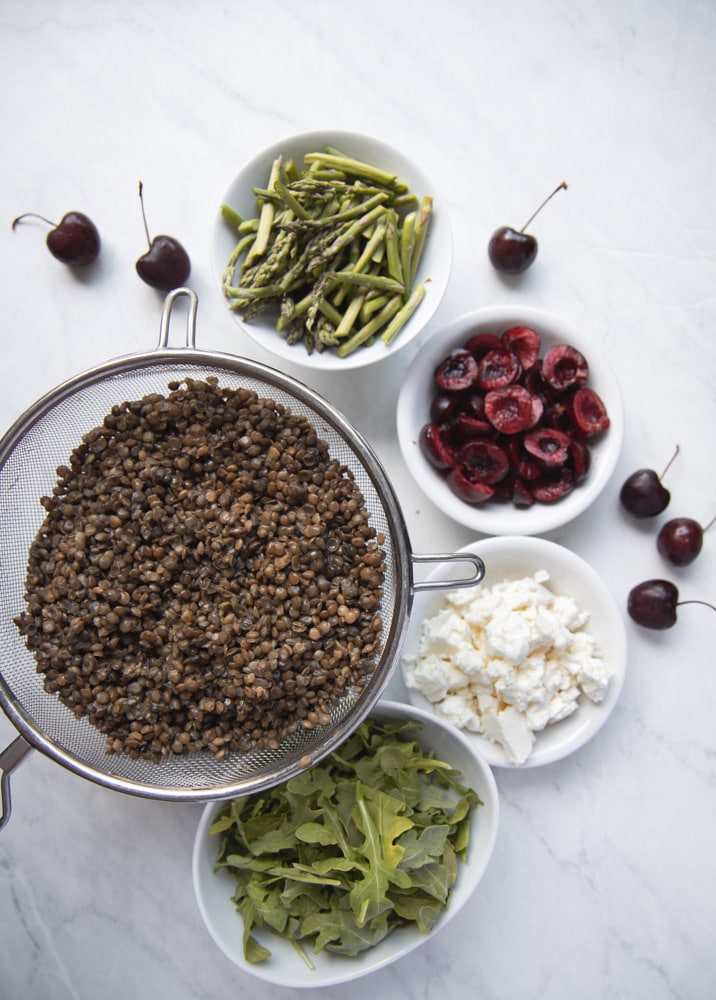 ingredients for cherry lentil salad in individual bowls