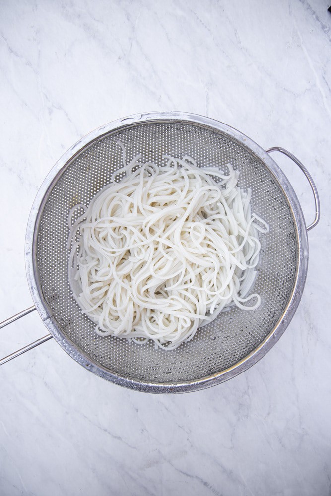 drained pad Thai noodles in a colander