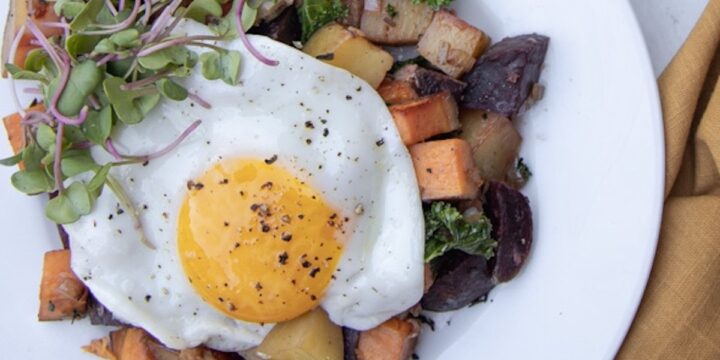 overhead shot of beet hash on plate with fried egg on top