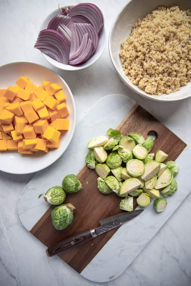 ingredients for nourish bowl prepped, with Brussel sprouts on a cutting board
