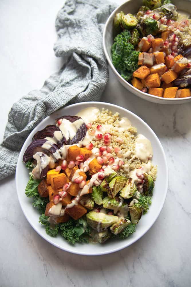 overhead shot of nourish bowl all plated with pomegranate seeds sprinkled on top