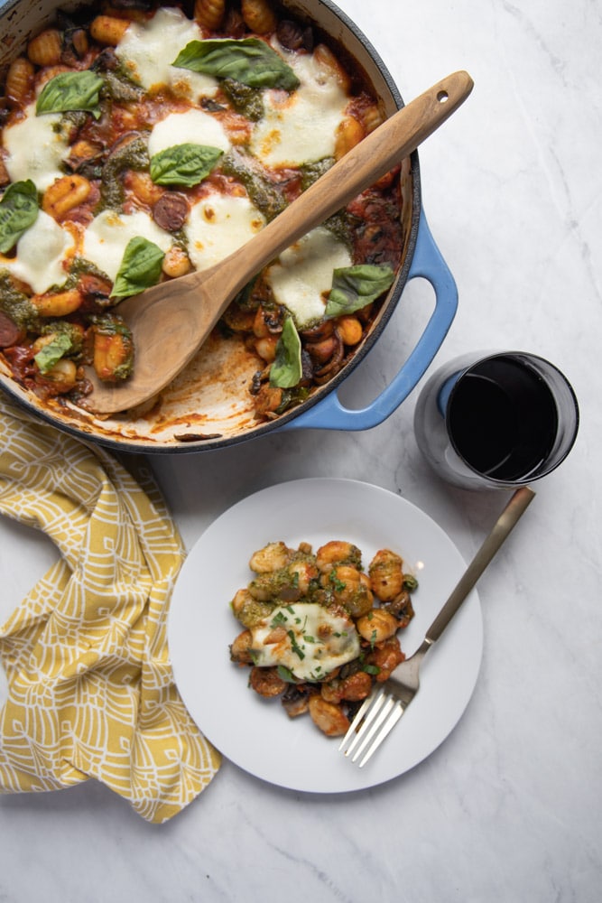 A plate of baked gnocchi and a glass of wine