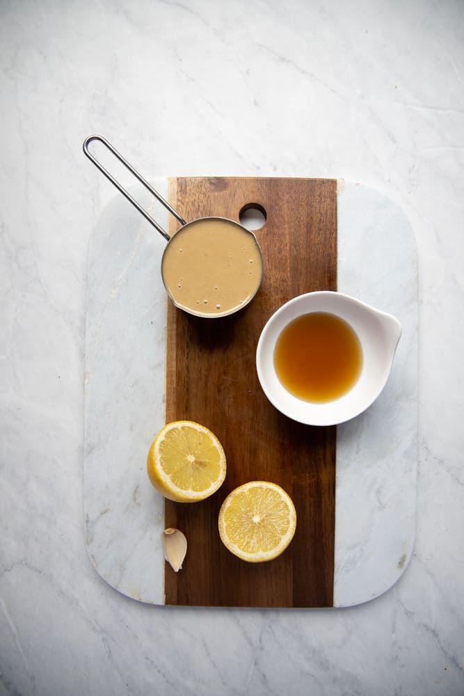 ingredients for maple tahini dressing on cutting board