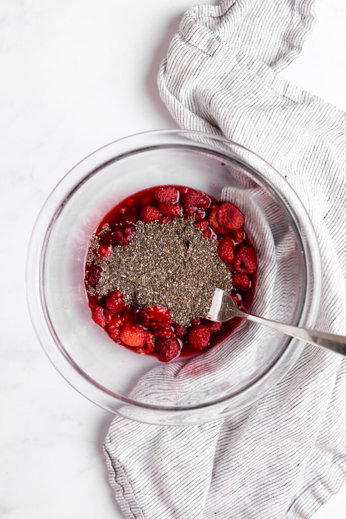 Raspberries with chia seeds in a mixing bowl.