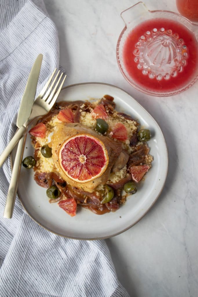 Plate of couscous topped with blood orange chicken