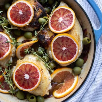 overhead shot of chicken in pan with blood orange slices on top