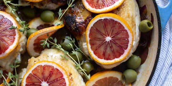 overhead shot of chicken in pan with blood orange slices on top
