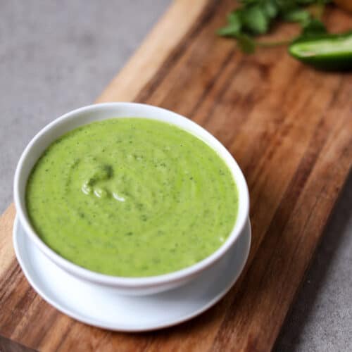 bowl of cilantro jalapeño sauce on wood cutting board