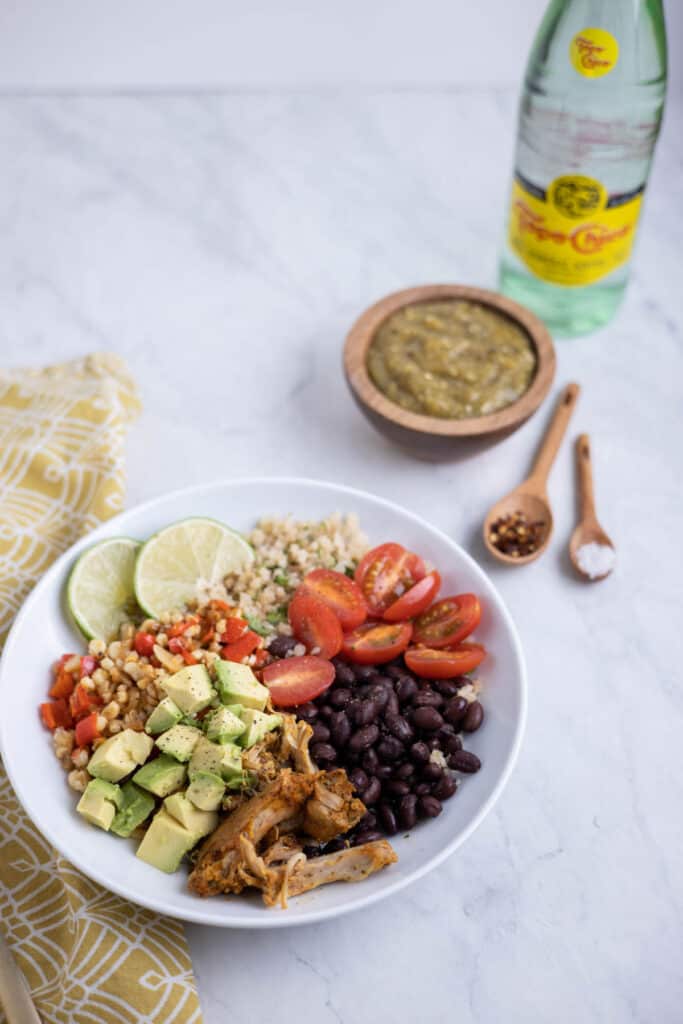 bowl of cauliflower rice topped with black beans, avocado and tomato