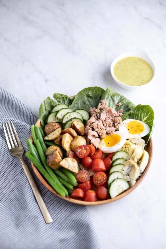 overhead shot of Nicoise Salad on a plate with tarragon tahini dressing