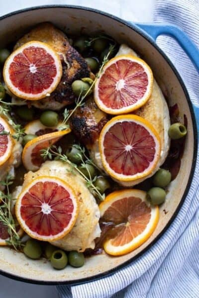 chicken thighs topped with blood orange slices in a skillet