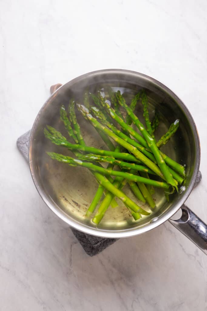 blanched asparagus in a pot of boiling water