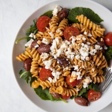 closeup image of bowl filled with romesco pasta salad