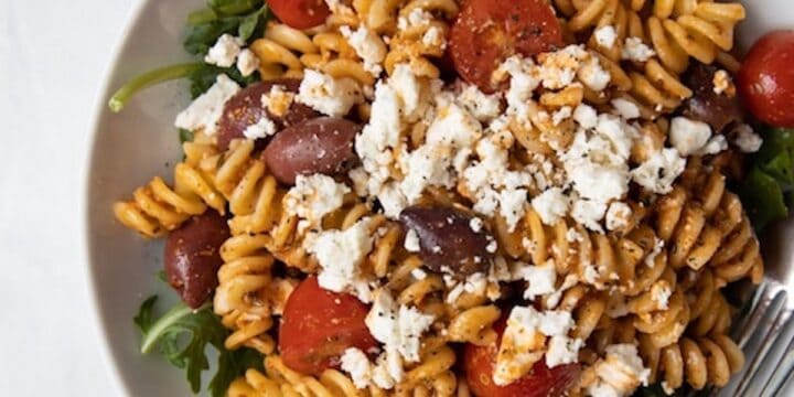 closeup image of bowl filled with romesco pasta salad