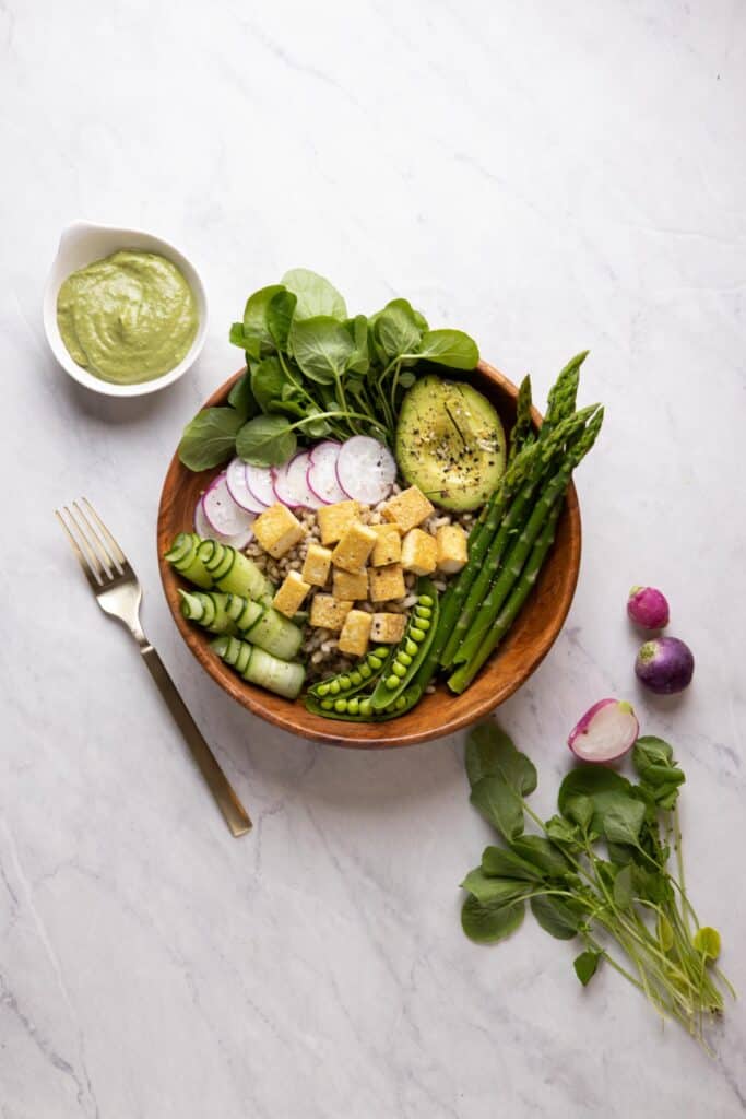 overhead photo of wooden bowl with spring grain bowl