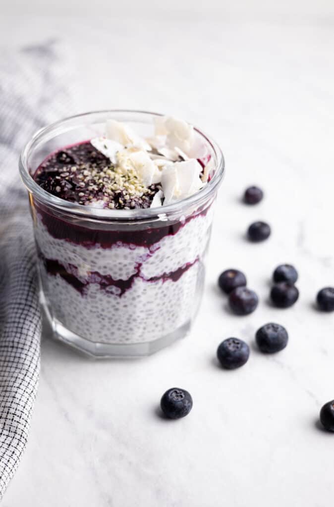 mason jar filled with coconut chia pudding and layers of blueberry compote