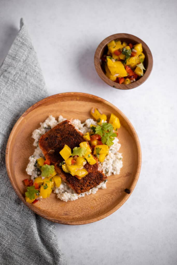 blackened salmon with mango salsa on a wooden plate