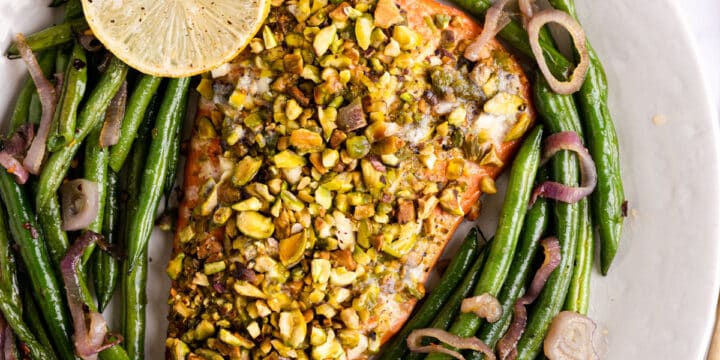overhead photo of salmon crusted with pistachio and roasted green beans
