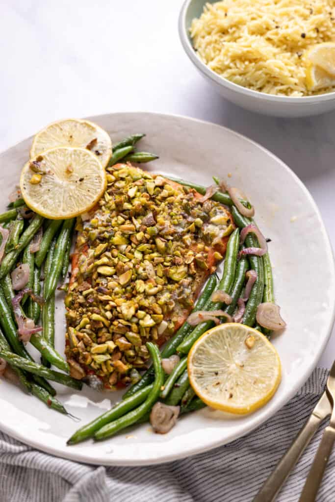 pistachio crusted salmon filet on a platter with green beans