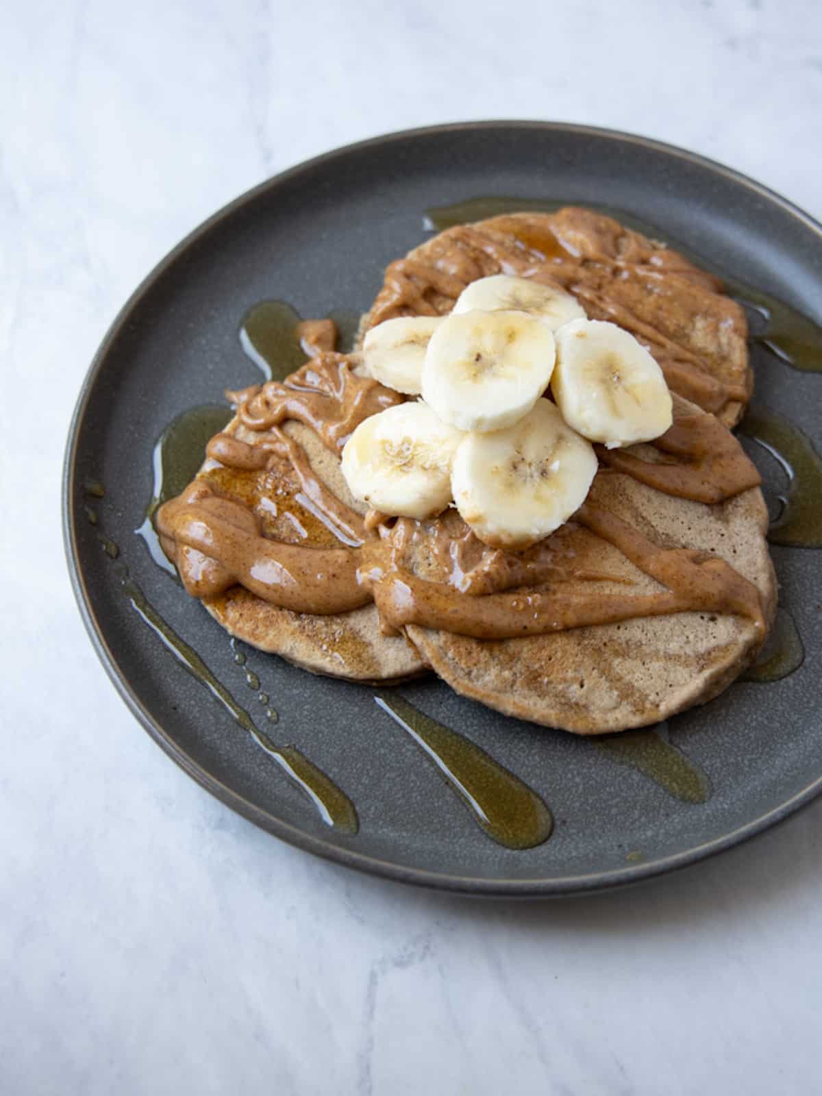 banana pancakes on plate with sliced bananas