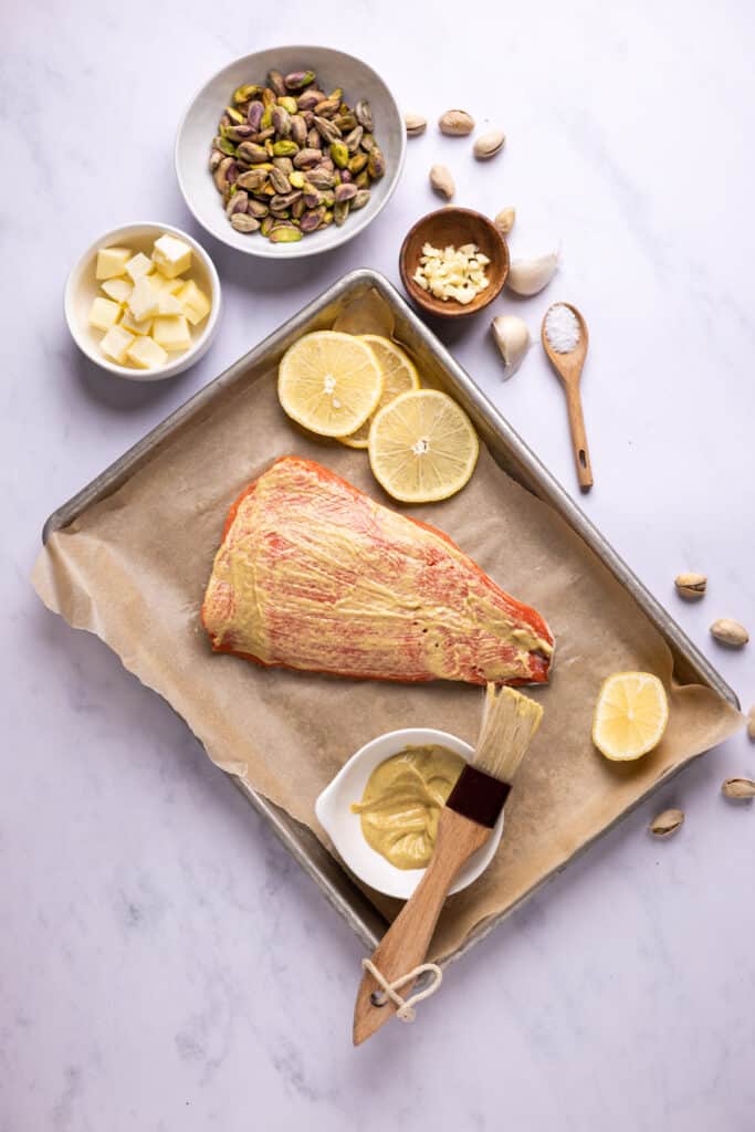 salmon slathered with Dijon Mustard on a sheet pan