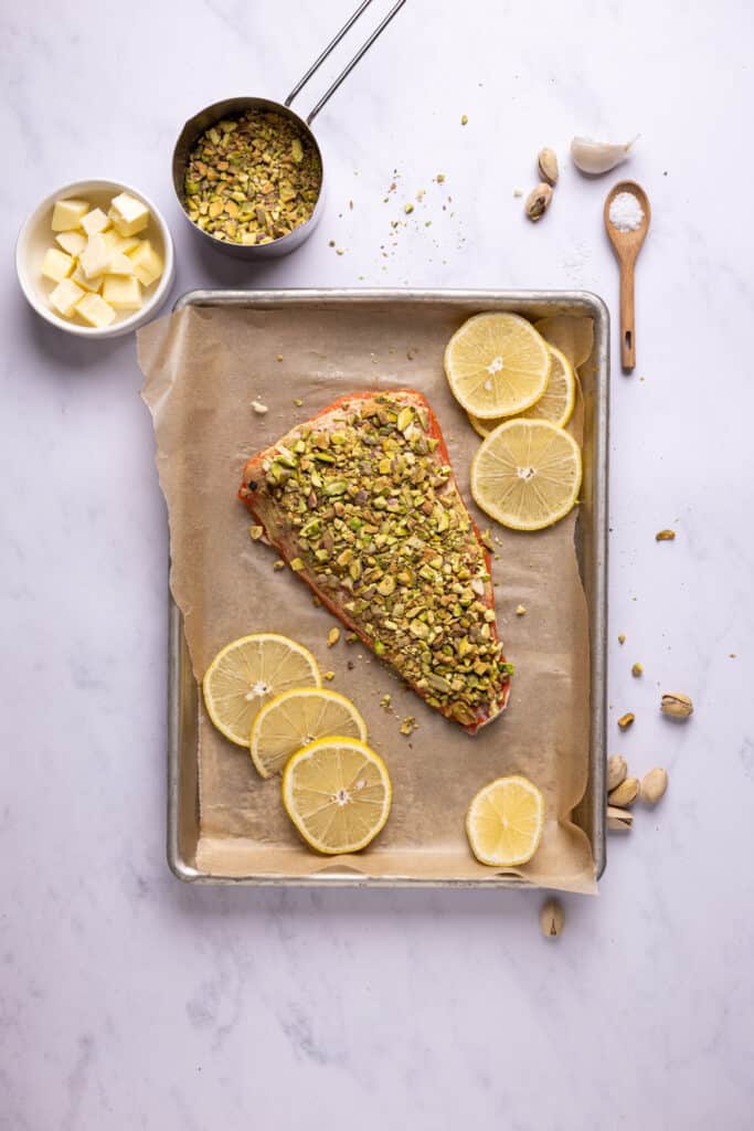 salmon topped with crushed pistachios on a sheet pan