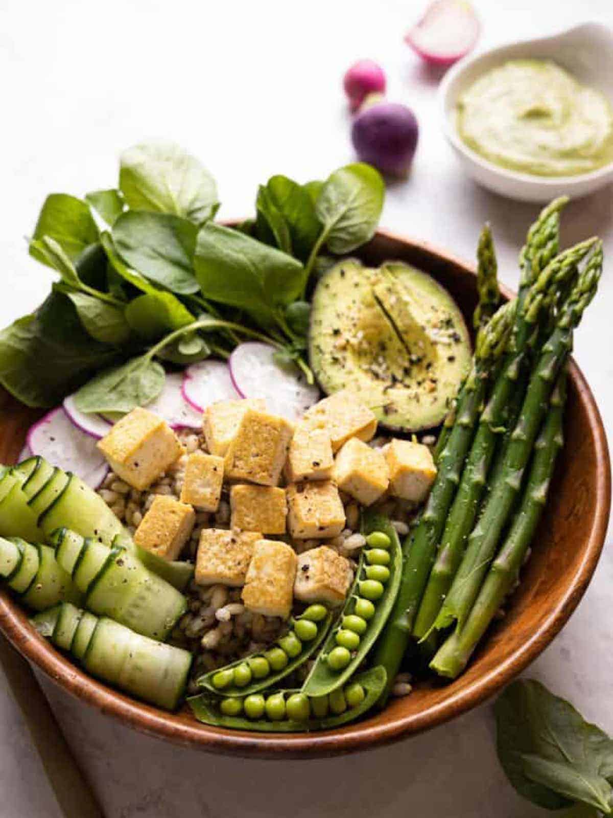 bowl filled with barley and fresh spring vegetables
