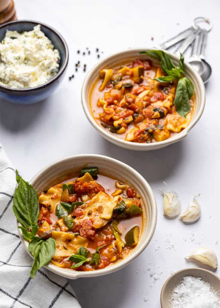 two bowls of vegetarian lasagna soup in a bowl without ricotta cheese on top