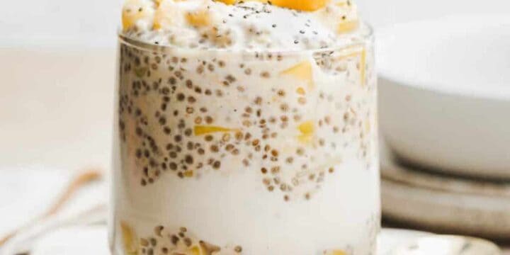 Glass cup filled with tropical overnight oats.