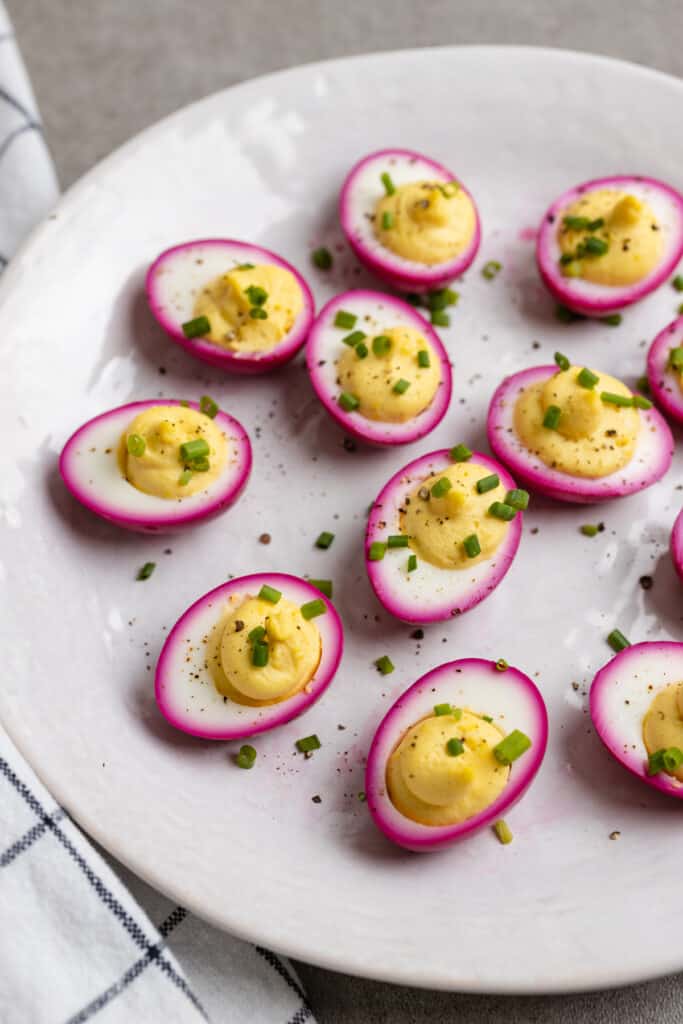 White platter full of beet deviled eggs.