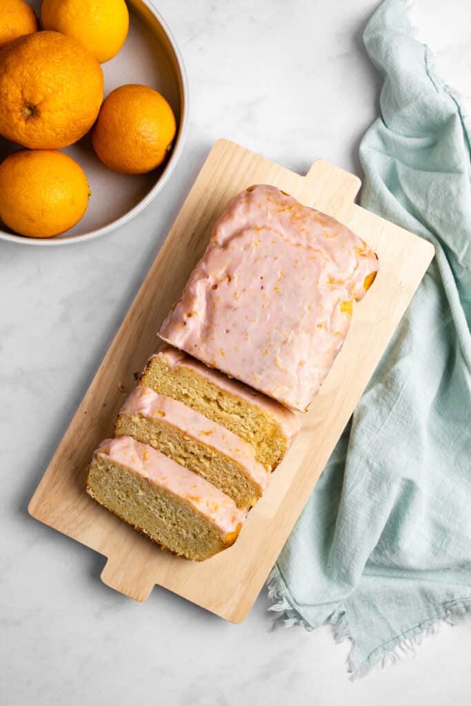 Blood orange yogurt loaf sliced on a cutting board.