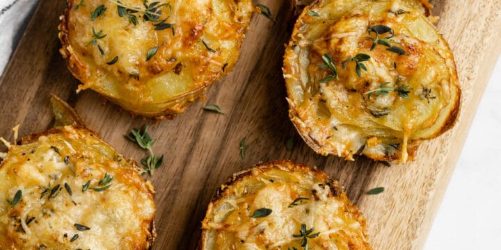 Stacks of potato and gruyere on a cutting board.