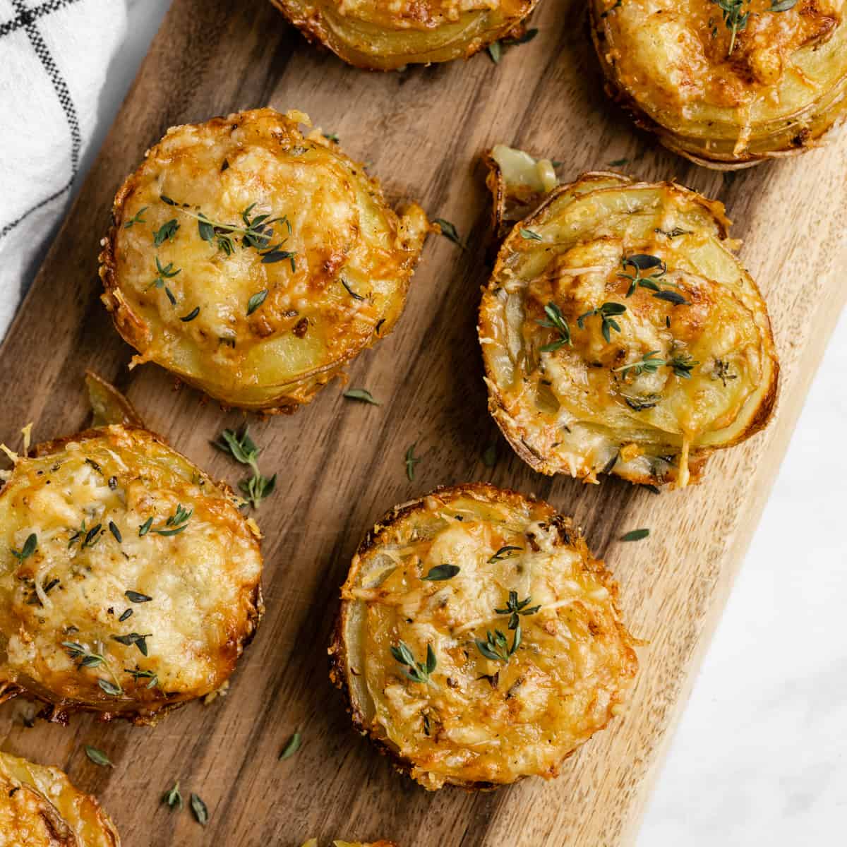 Stacks of potato and gruyere on a cutting board.