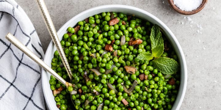 Peas and pancetta with mint in a serving bowl.