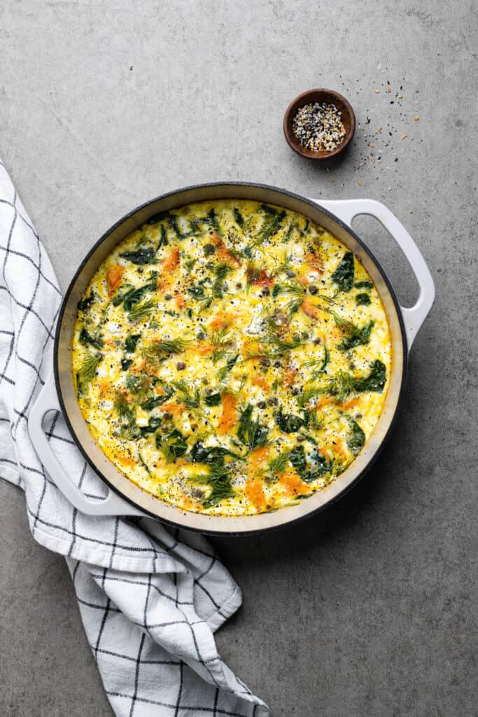 White cast iron pan with smoked salmon fritatta.