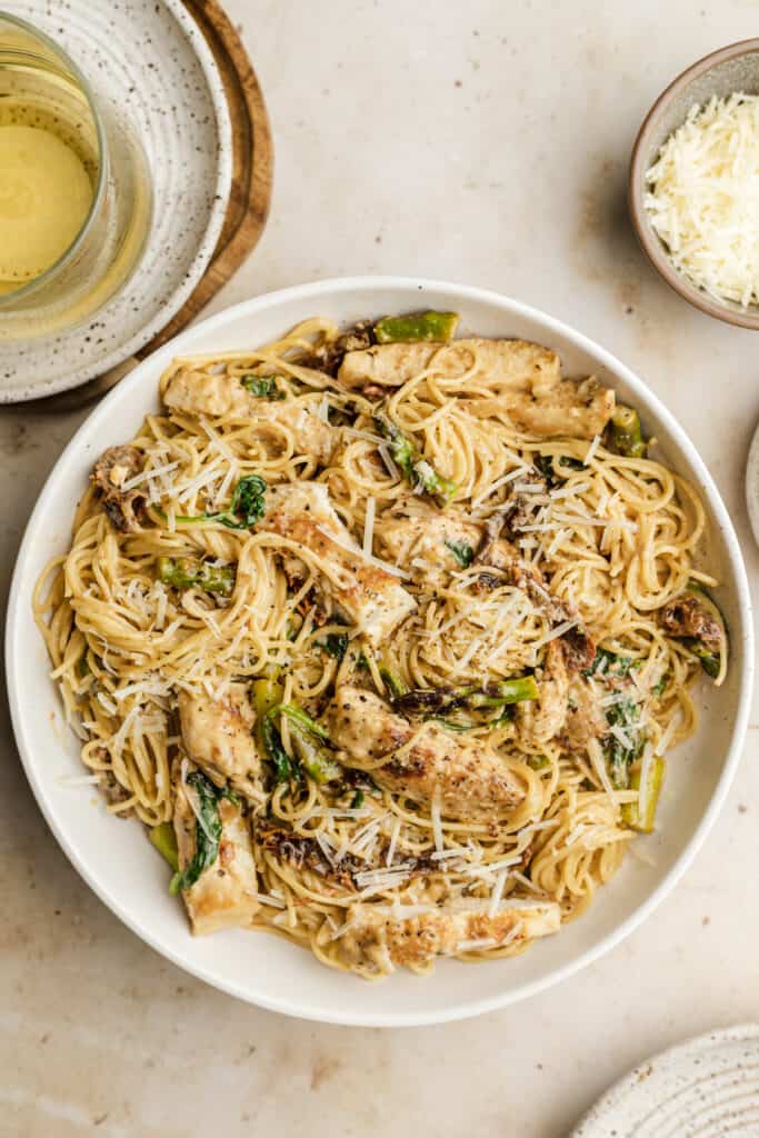 Sun dried tomato pasta chicken in a white serving bowl.