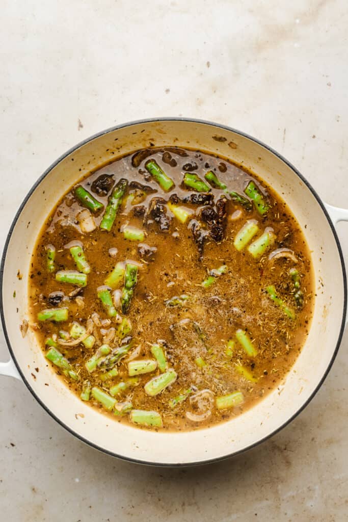Skillet with chicken stock mixture to make sauce.